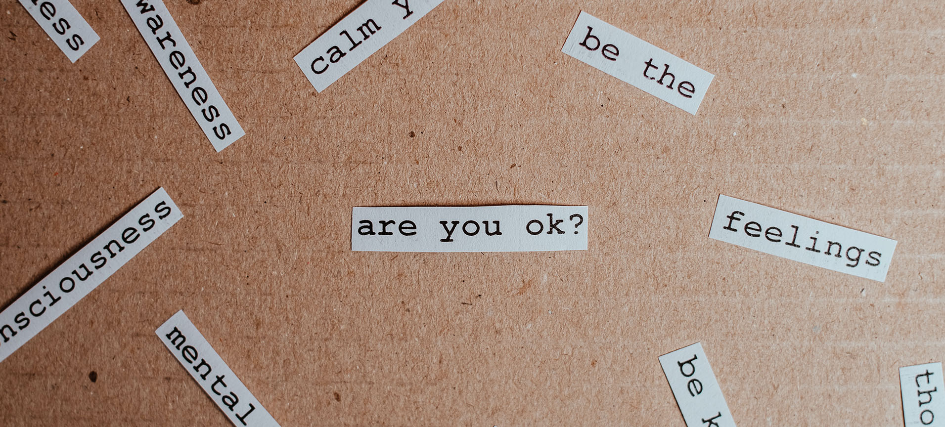 small phrases on white pieces of paper: are you ok?; feelings; mental; calm; be the; awareness 