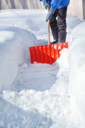 person shoveling heavy snow
